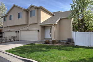 View of front of house with driveway, stucco siding, an attached garage, and roof with shingles