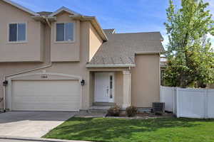 Traditional home with roof with shingles, stucco siding, an attached garage, and driveway