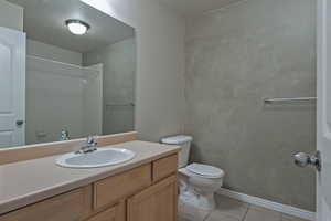 Bathroom with vanity, light tile patterned flooring, and a shower