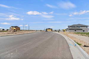 View of asphalt road featuring curbs and a residential view