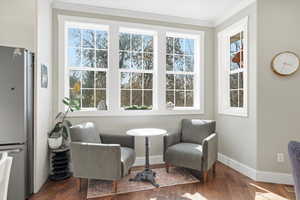 Living area featuring dark wood finished floors and crown molding