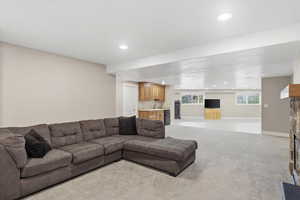 Living area featuring wet bar, light colored carpet, and recessed lighting