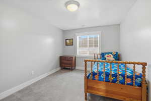 Bedroom featuring light carpet and a textured ceiling