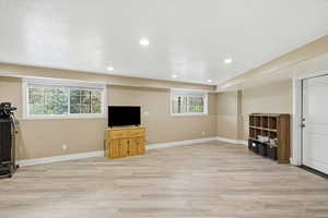 Unfurnished living room with light wood finished floors, plenty of natural light, and recessed lighting