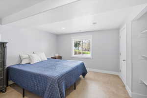 Bedroom with light colored carpet and recessed lighting