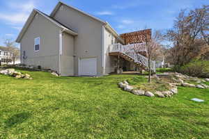 View of home's exterior featuring a garage, a wooden deck, and a yard