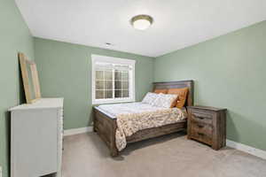 Bedroom featuring baseboards and light carpet