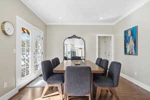 Dining area with hardwood / wood-style floors, ornamental molding, recessed lighting, and french doors