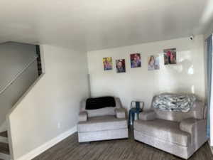 Living area featuring dark wood-style flooring and baseboards