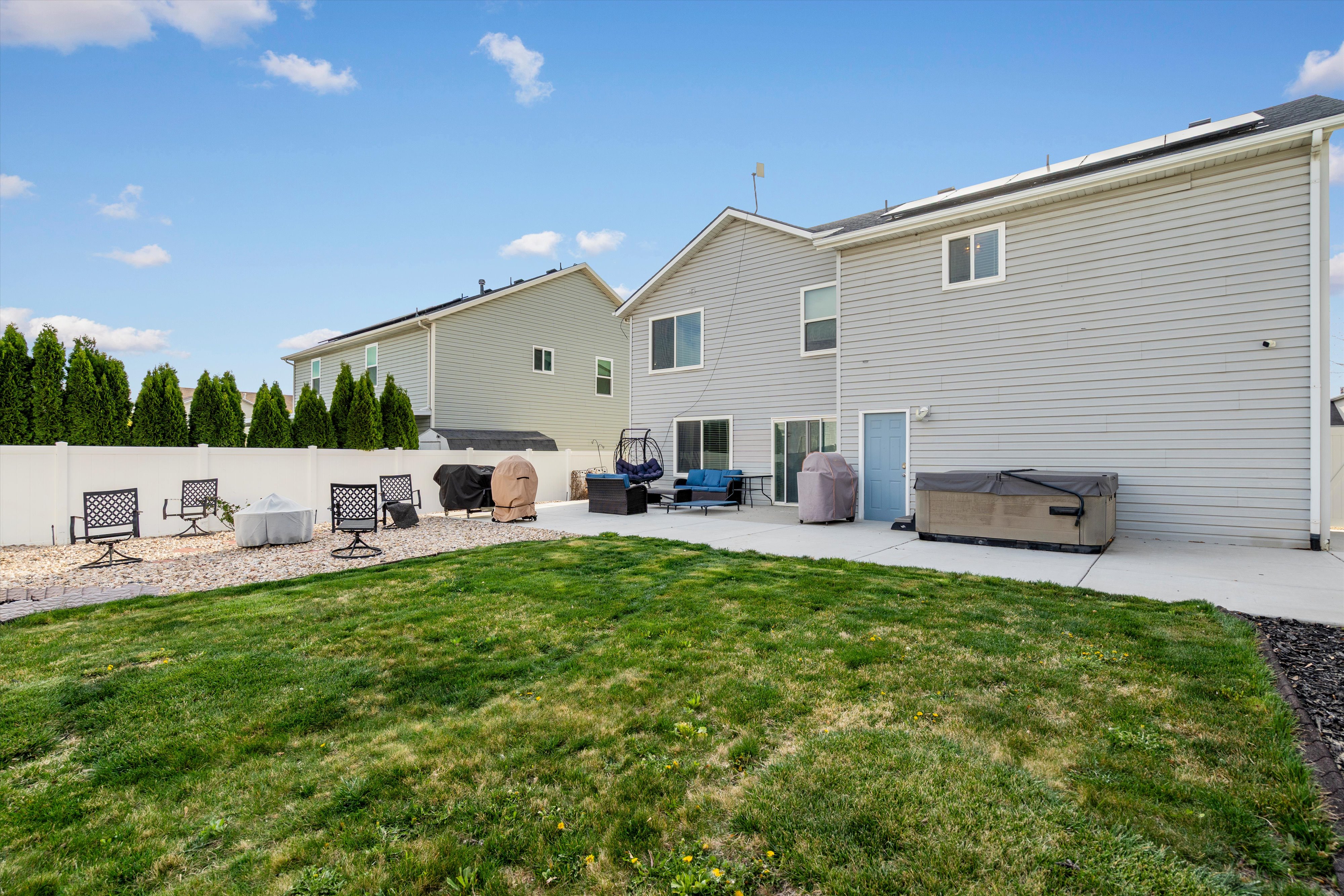 Back of house featuring a patio area, a hot tub, and a fenced backyard
