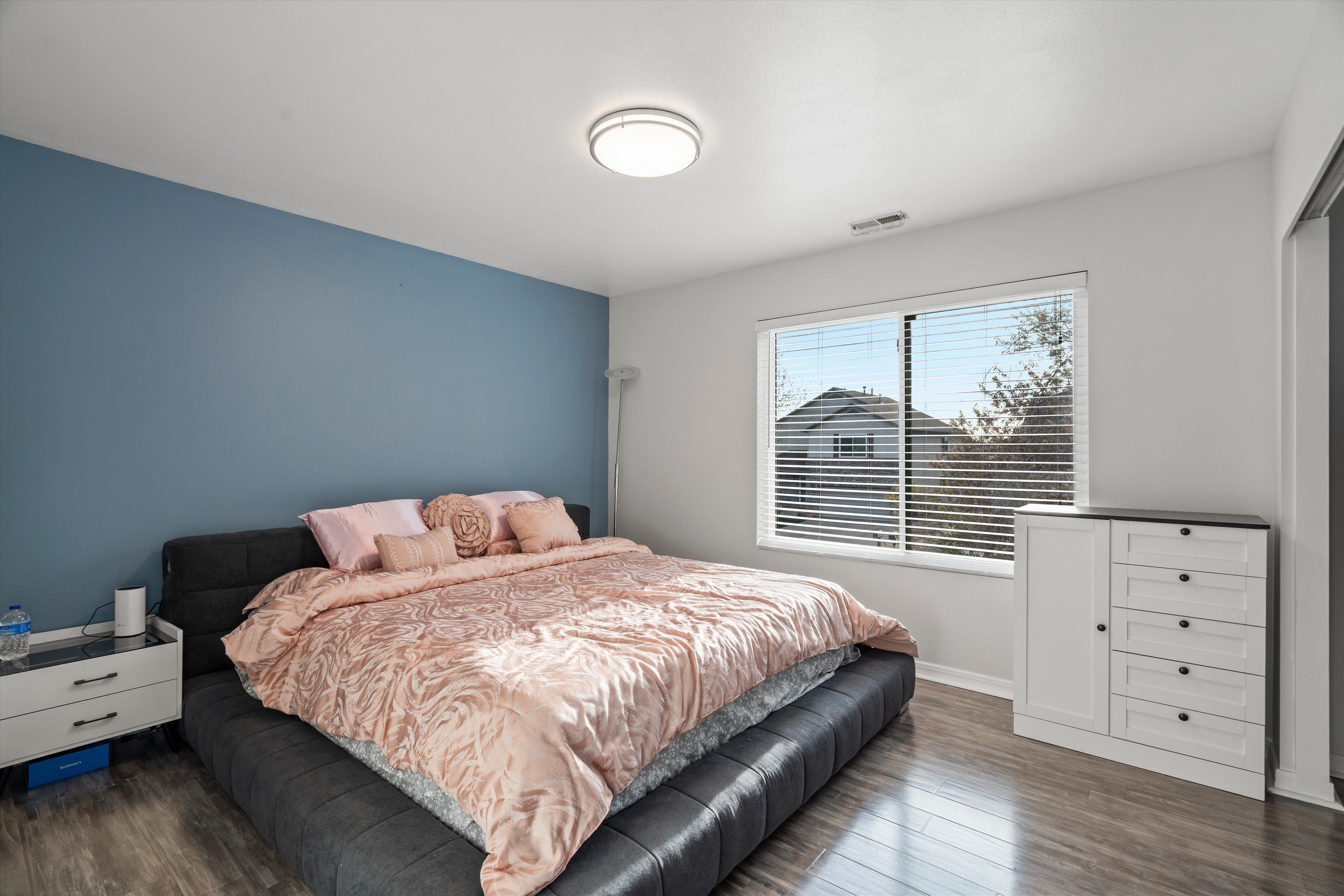 Bedroom with dark wood-type flooring and baseboards