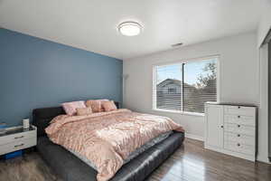 Bedroom with dark wood-type flooring and baseboards