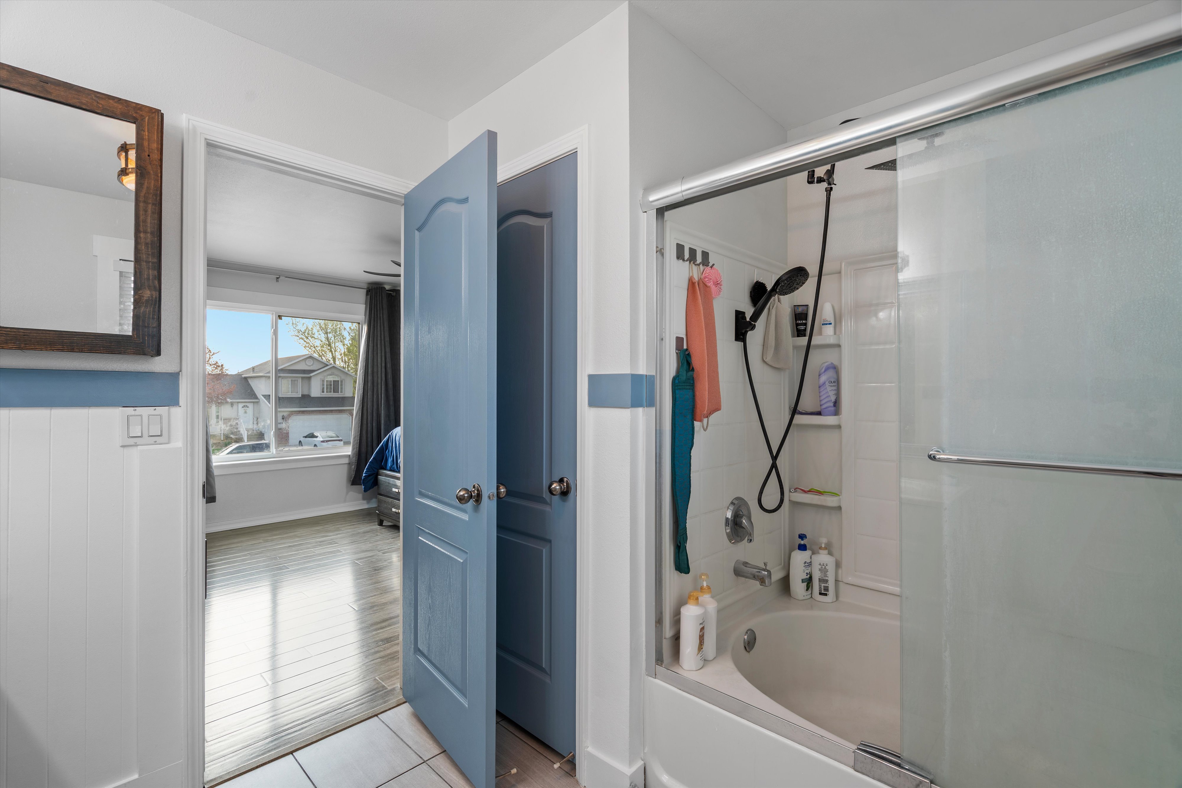 Bathroom featuring combined bath / shower with glass door and light tile patterned floors