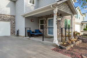 View of exterior entry with a porch, brick siding, and driveway