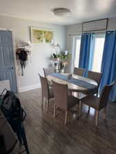 Dining space featuring dark wood finished floors and baseboards