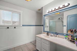 Full bath with a stall shower, vanity, wainscoting, and wooden walls