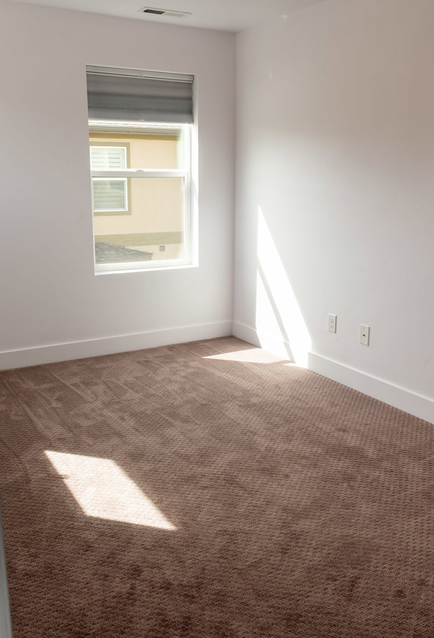 Empty room with carpet floors and baseboards