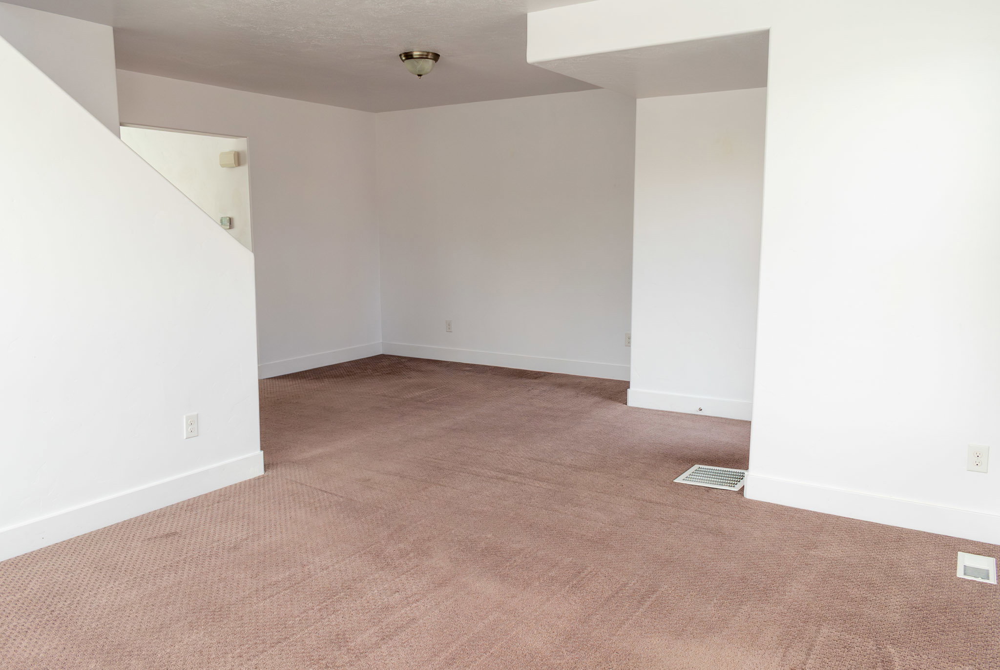 Spare room with baseboards and light colored carpet