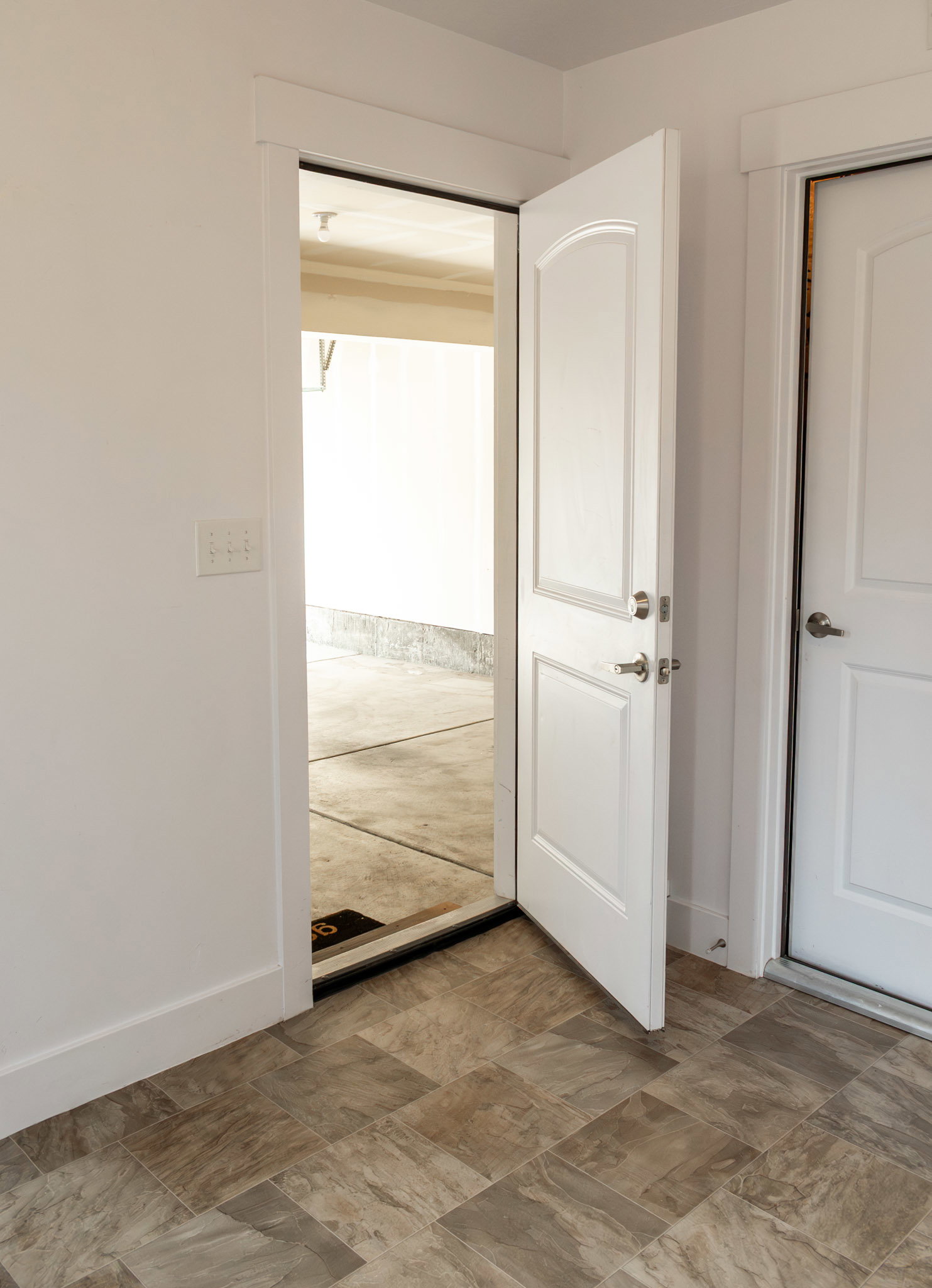 Doorway with baseboards and stone finish flooring