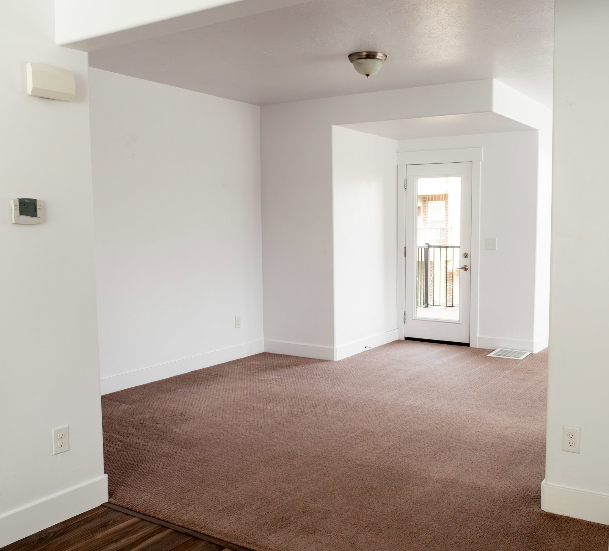 Spare room with baseboards and dark carpet