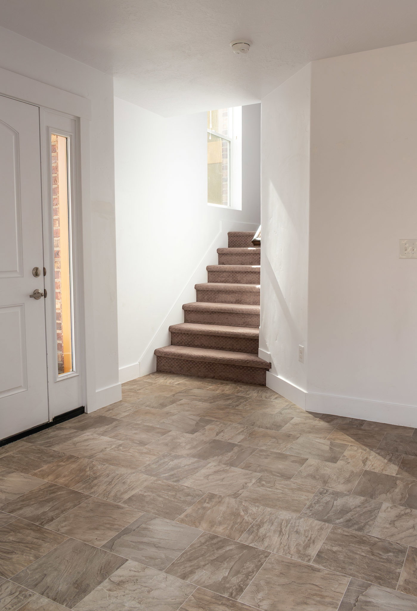 Foyer entrance with stairs and baseboards