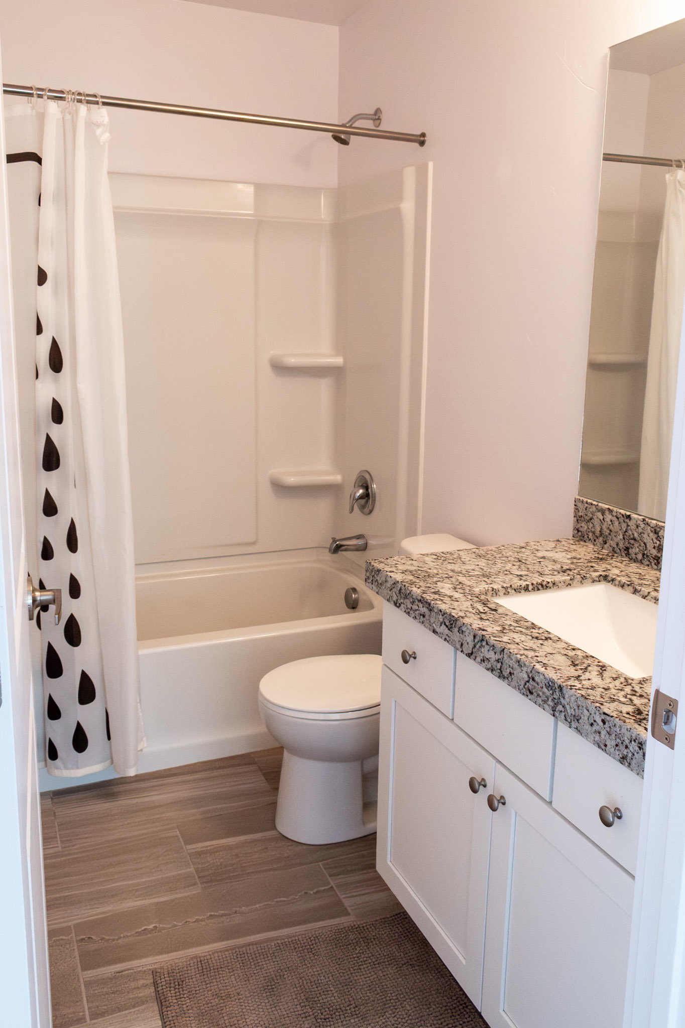 Full bath with vanity, dark wood-style flooring, and shower / tub combo