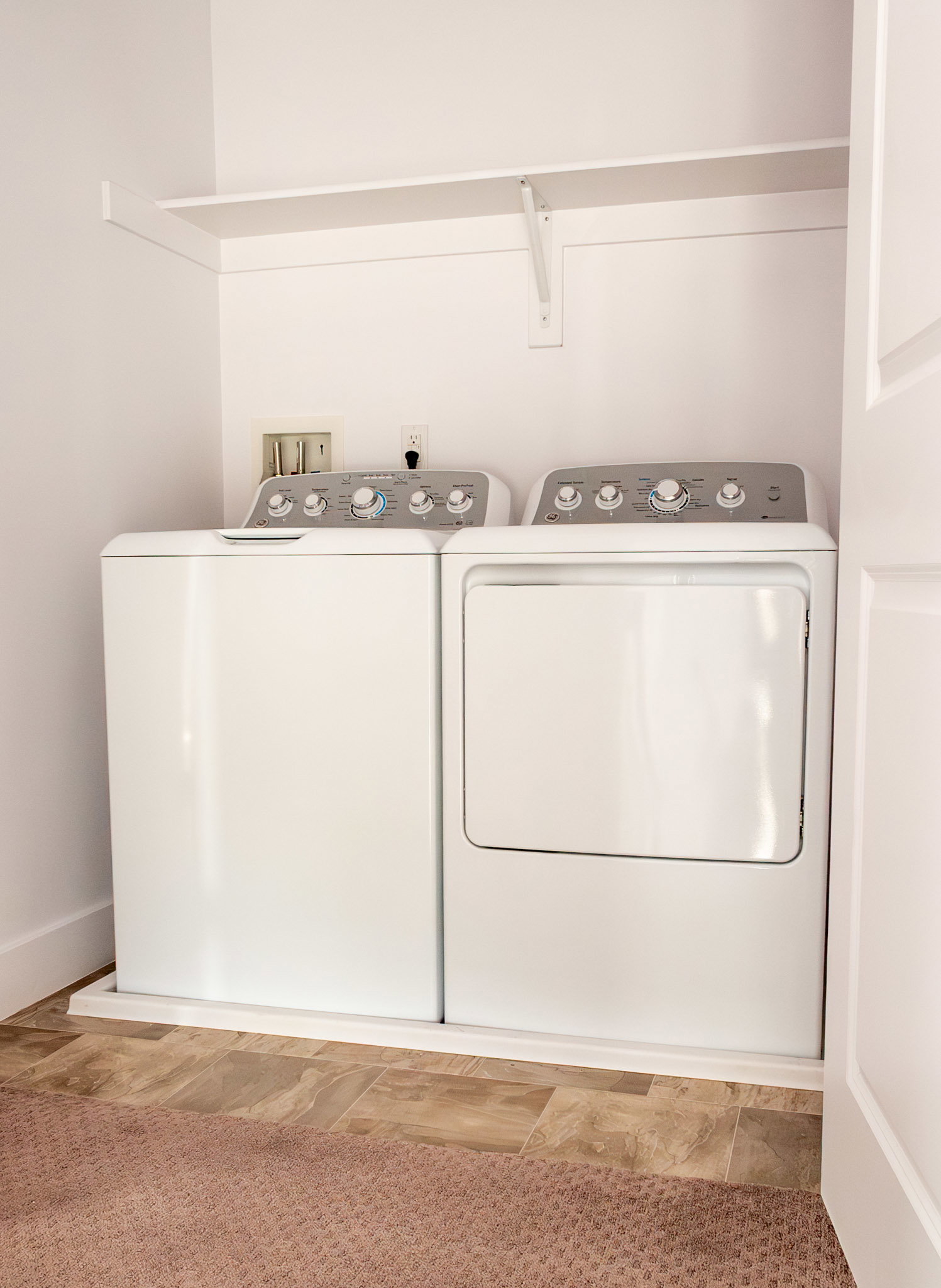 Laundry area with independent washer and dryer and baseboards