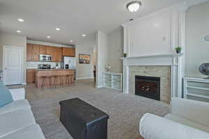 Living area with light tile patterned flooring, a fireplace, recessed lighting, and light colored carpet