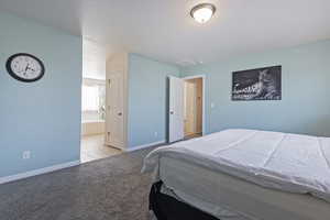 Bedroom with light colored carpet and connected bathroom