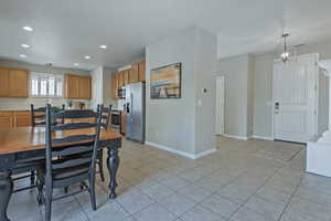 Dining space featuring light tile patterned flooring and a chandelier