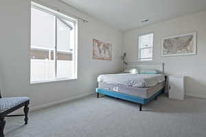 Bedroom featuring light colored carpet and baseboards