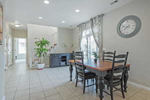 Dining room with light tile patterned flooring and recessed lighting