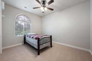 Bedroom with light colored carpet and ceiling fan