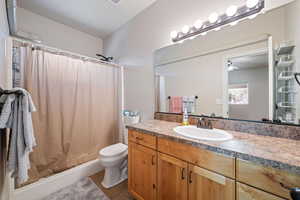 Full bathroom with vanity, curtained shower, and dark tile patterned floors