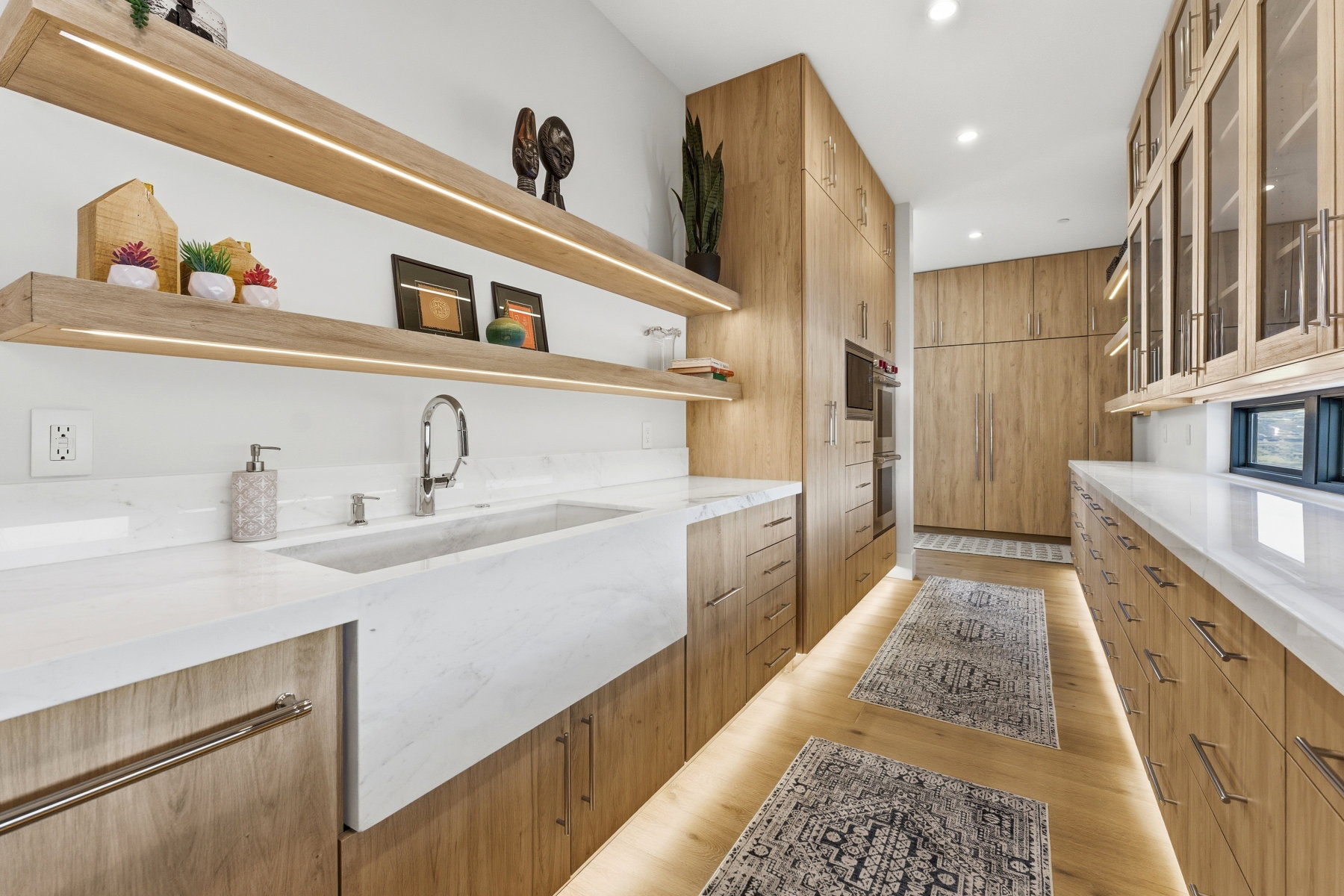 Kitchen featuring light wood-style floors, light stone counters, modern cabinets, glass insert cabinets, and open shelves