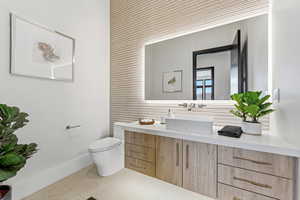 Half bath featuring vanity and tile walls