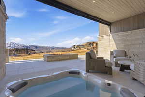View of patio / terrace with a mountain view and an outdoor hot tub