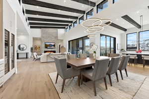 Dining room featuring a fireplace, light wood-type flooring, recessed lighting, and plenty of natural light