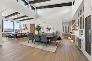 Dining room with beverage cooler, light wood-type flooring, and recessed lighting