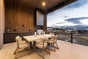 Dining area featuring a mountain view, wood walls, wooden ceiling, and light tile patterned floors