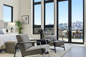 Bedroom featuring multiple windows, light wood-type flooring, a mountain view, and expansive windows