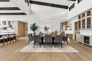 Dining room featuring wine cooler, light wood-style floors, and recessed lighting