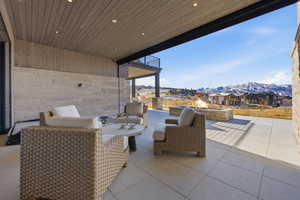 View of patio with a mountain view, an outdoor living space with a fire pit, and a residential view