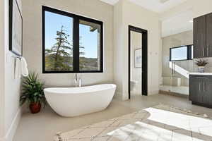 Full bath with a soaking tub, a stall shower, vanity, and finished concrete floors
