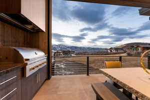 View of patio with a mountain view and area for grilling