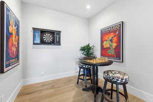 Dining area with light wood finished floors and recessed lighting