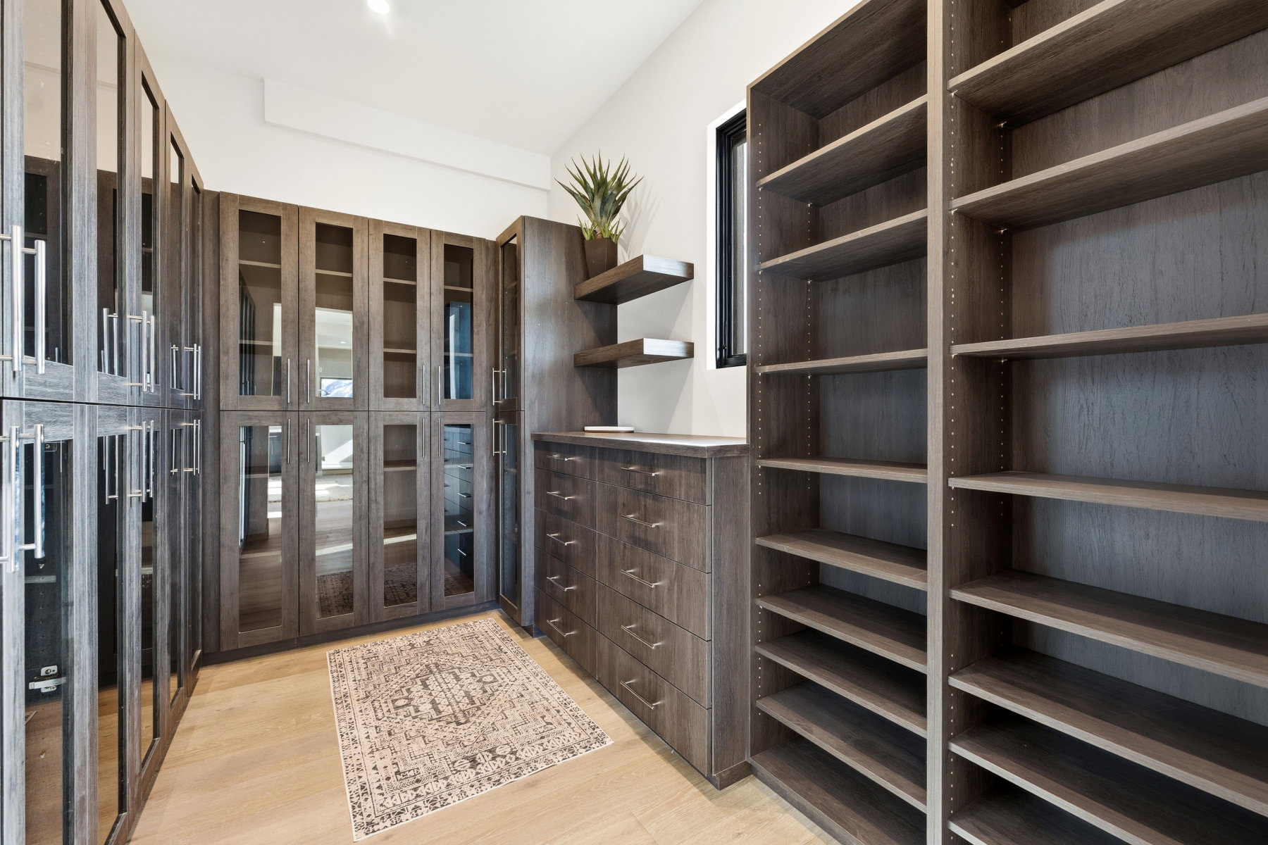 Walk in closet with light wood finished floors