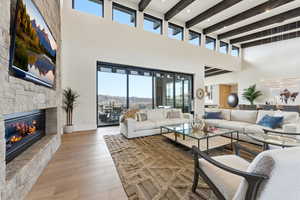 Living area with light wood-style flooring and a stone fireplace