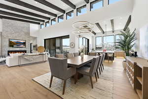 Dining area featuring light wood-style floors, a fireplace, recessed lighting, and plenty of natural light