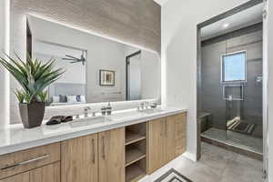 Bathroom with double vanity, a stall shower, and light tile patterned floors